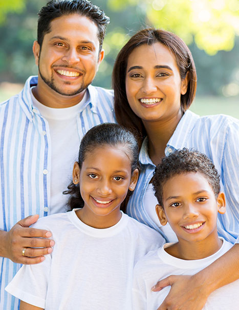 family-of-four-in-park man smiling in park